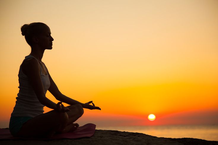 ध्यान करती हुई महिला सुबह की रोशनी में